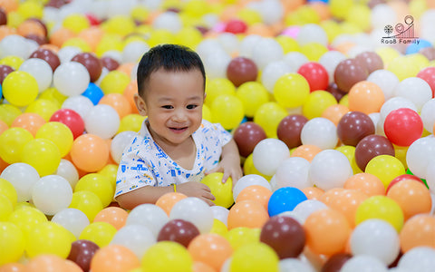 A Baby Playing In An Indoor Playpen