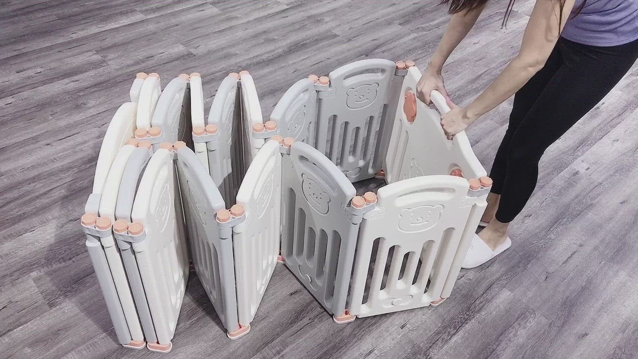 Foldable gray baby playpen being compacted by a person